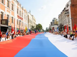 Участники «Парада регионов» в Нижнем Новгороде в День России пронесли по центральной улице города стометровый триколор